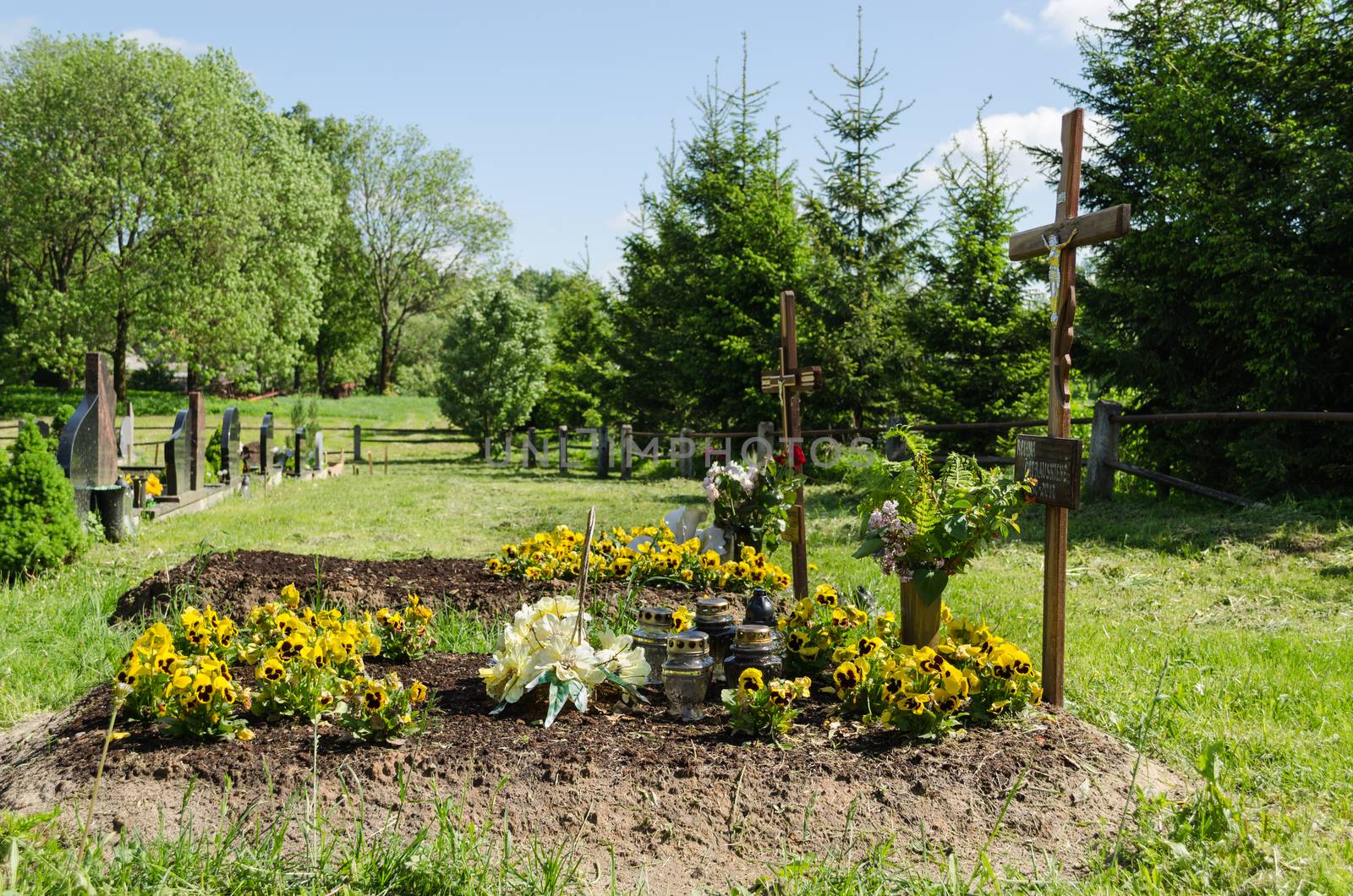 Freshly made grave soil flowers and foundation in cemetery.