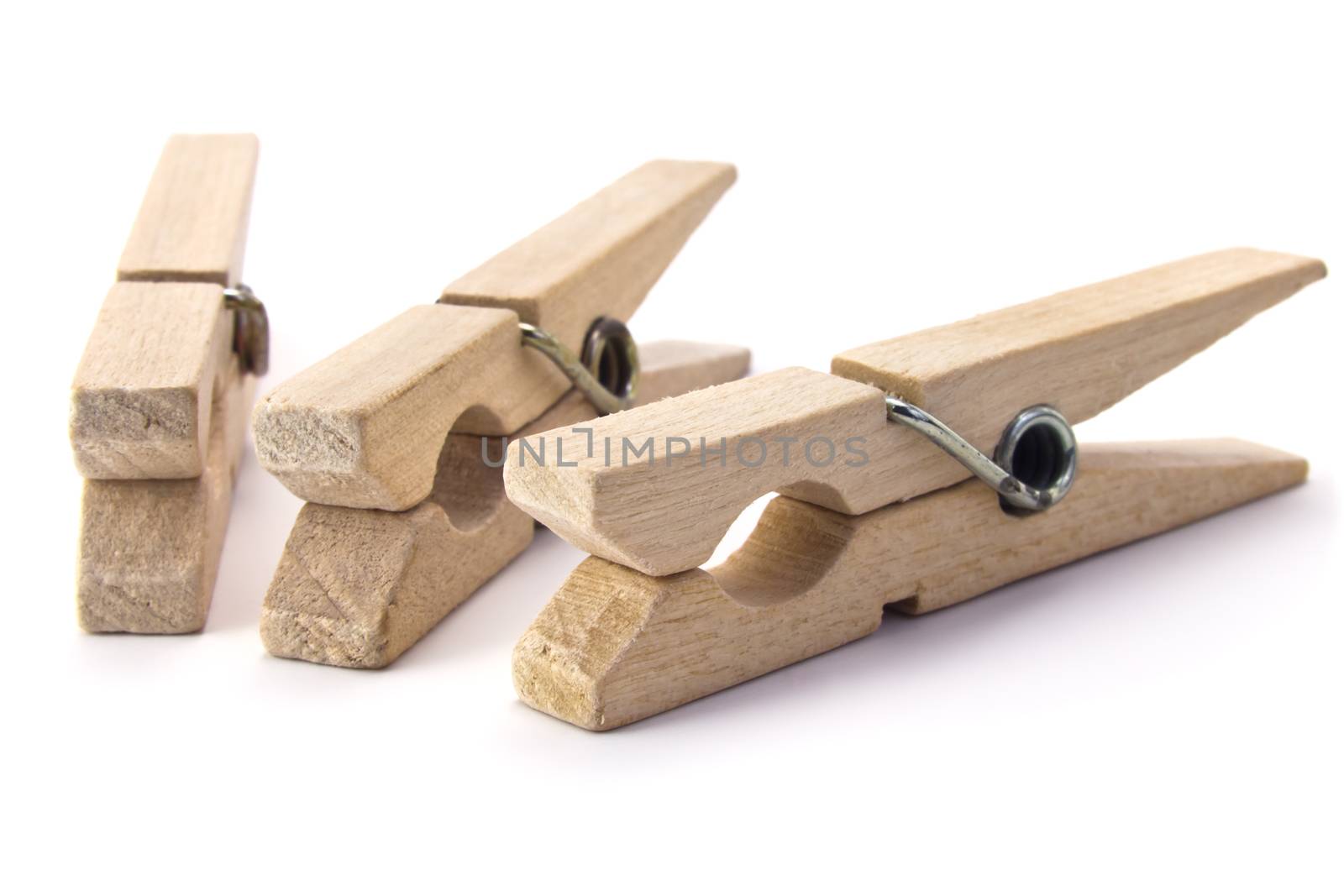  three wooden clothes pegs isolated on white background