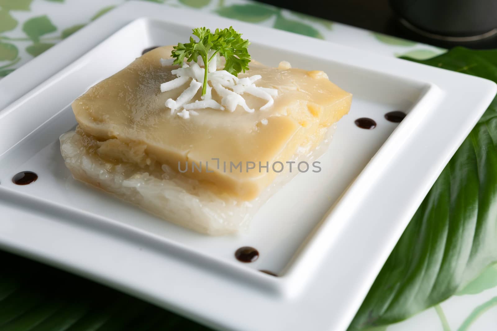 Thai custard with sticky rice garnished on a plate with shredded coconut.