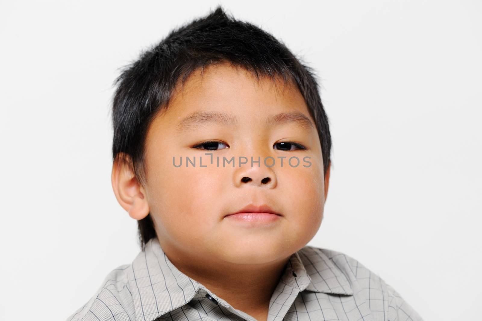 Asian boy with chubby cheeks looks serious