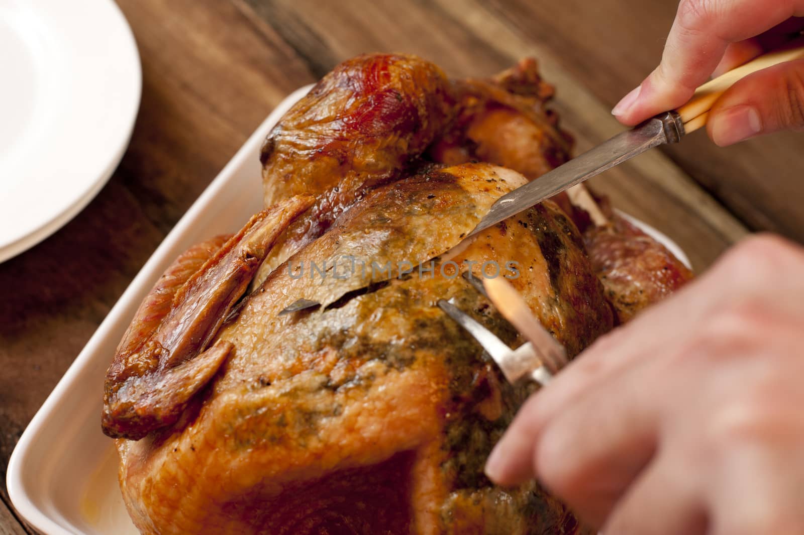 Man carving a delicious brown roast chicken by stockarch