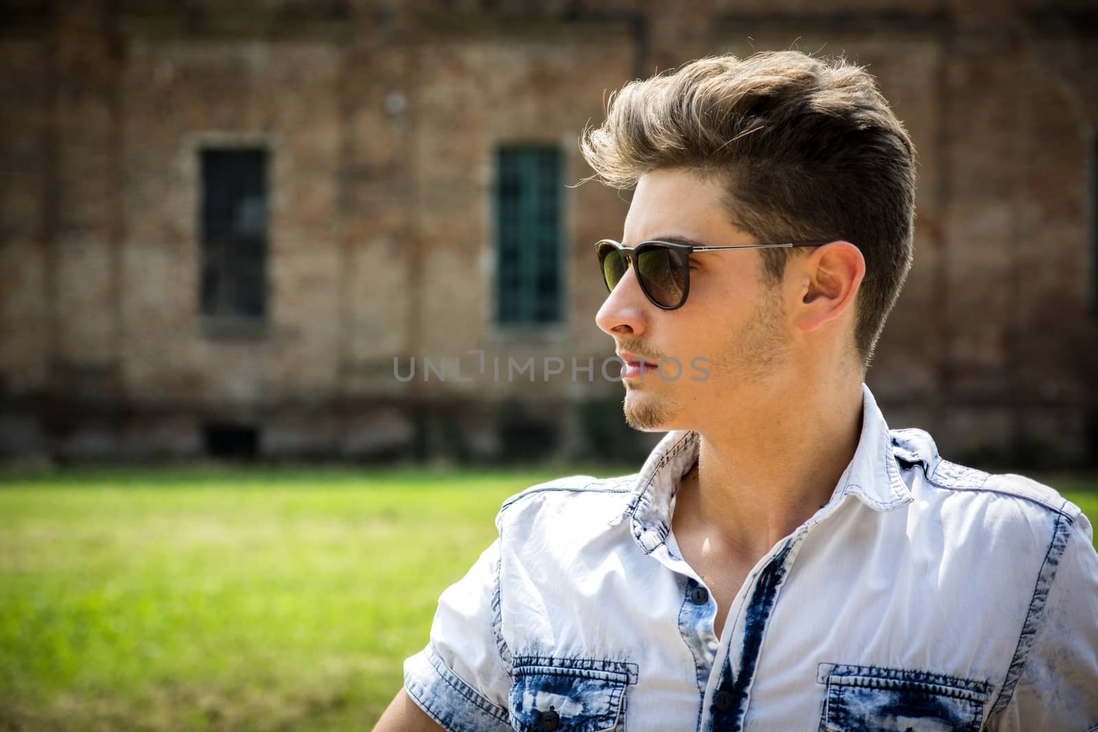 Handsome young man outdoors wearing sunglasses by artofphoto