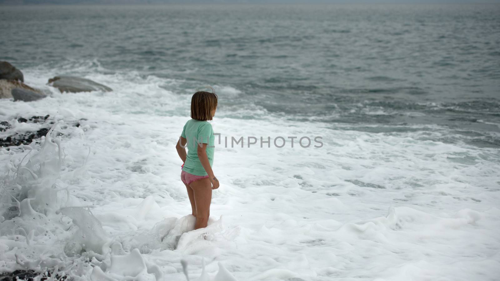 little girl on the seashore thinking about the summer is coming