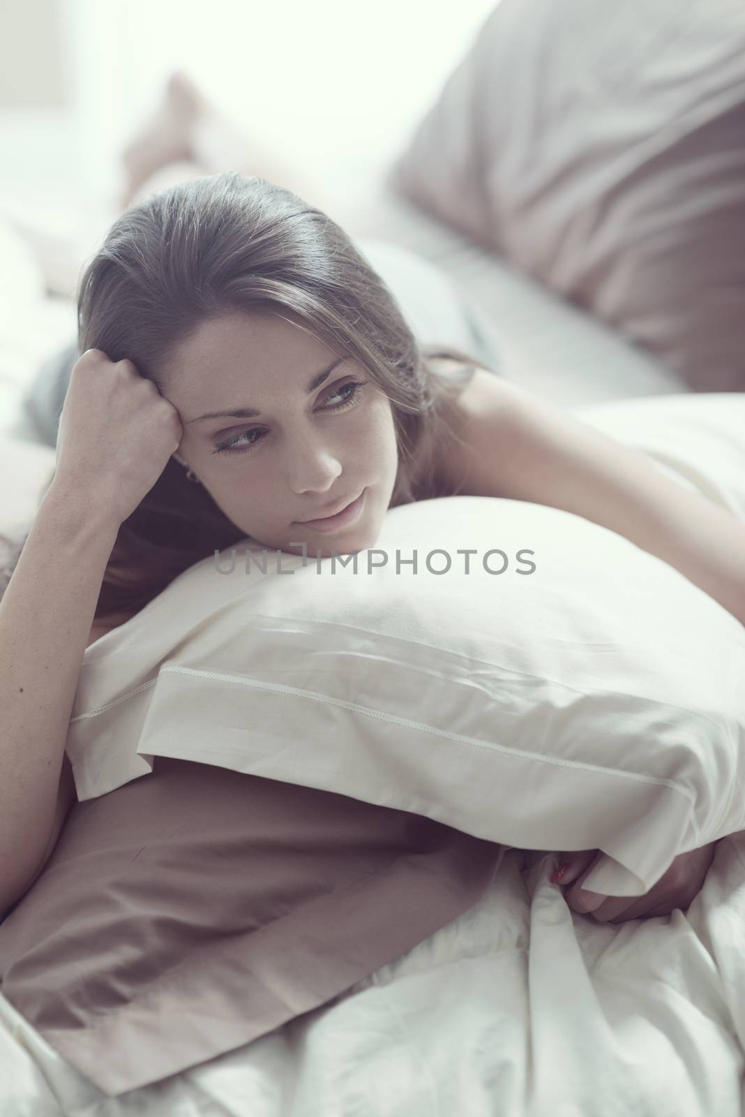 A gorgeous young woman while lying in bed 
