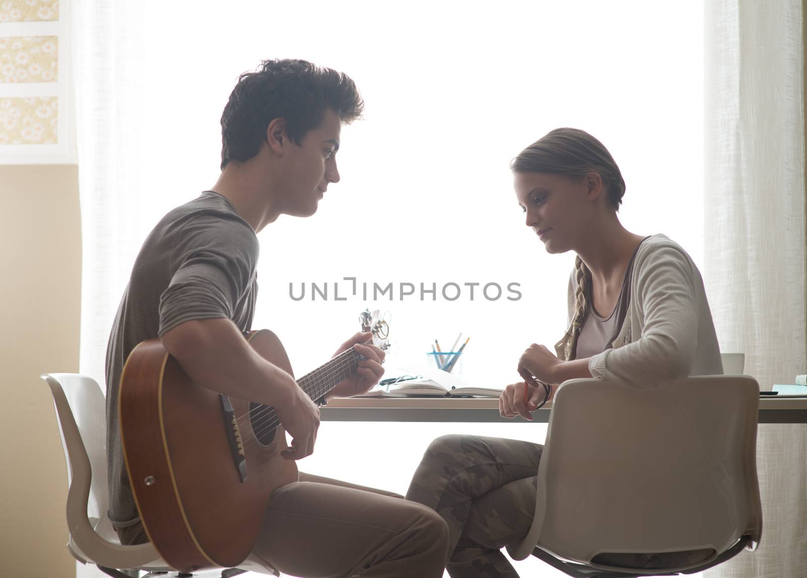 Young handsome man playing guitar for his girlfriend