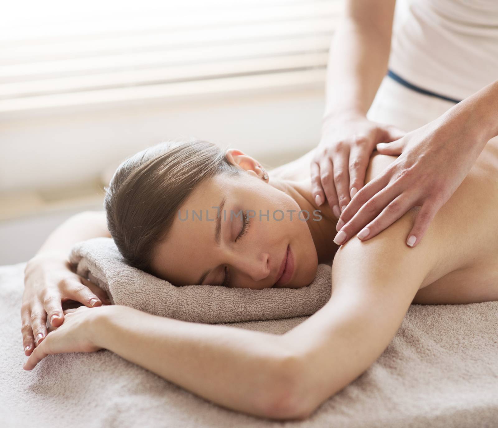 Beautiful woman receiving a relaxing back massage at spa.