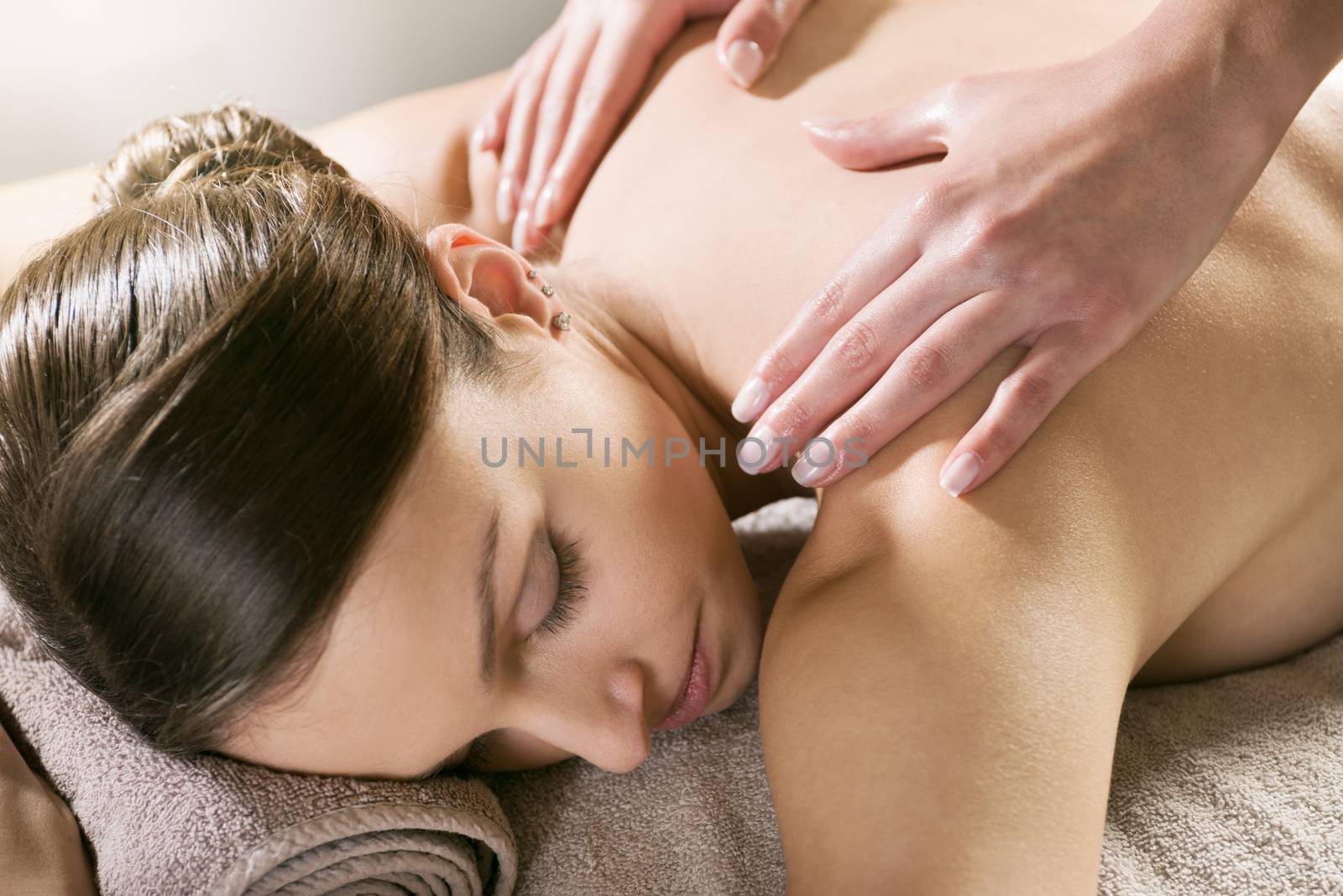 Beautiful woman receiving a relaxing back massage at spa.