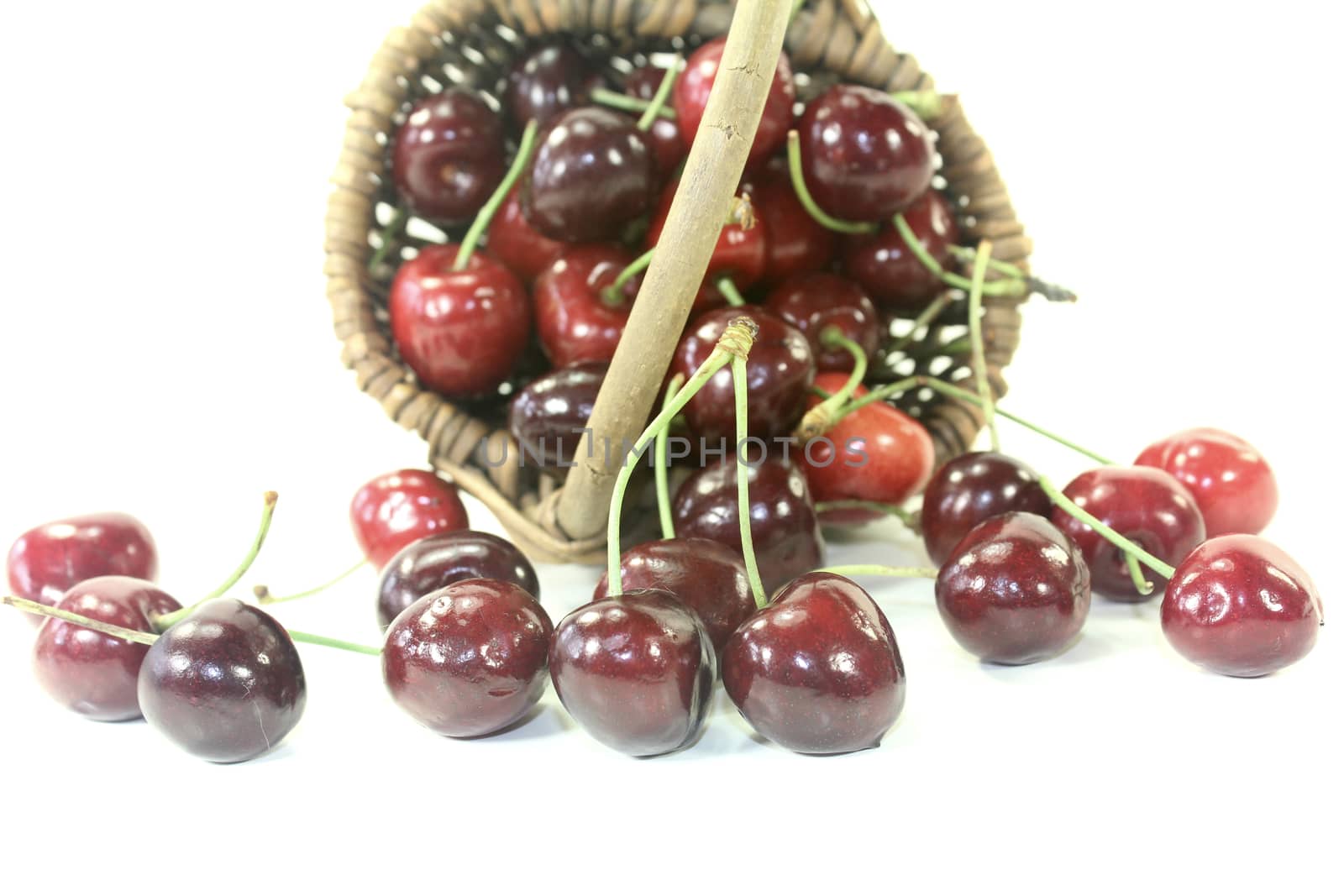 fresh red cherries in a basket on light background