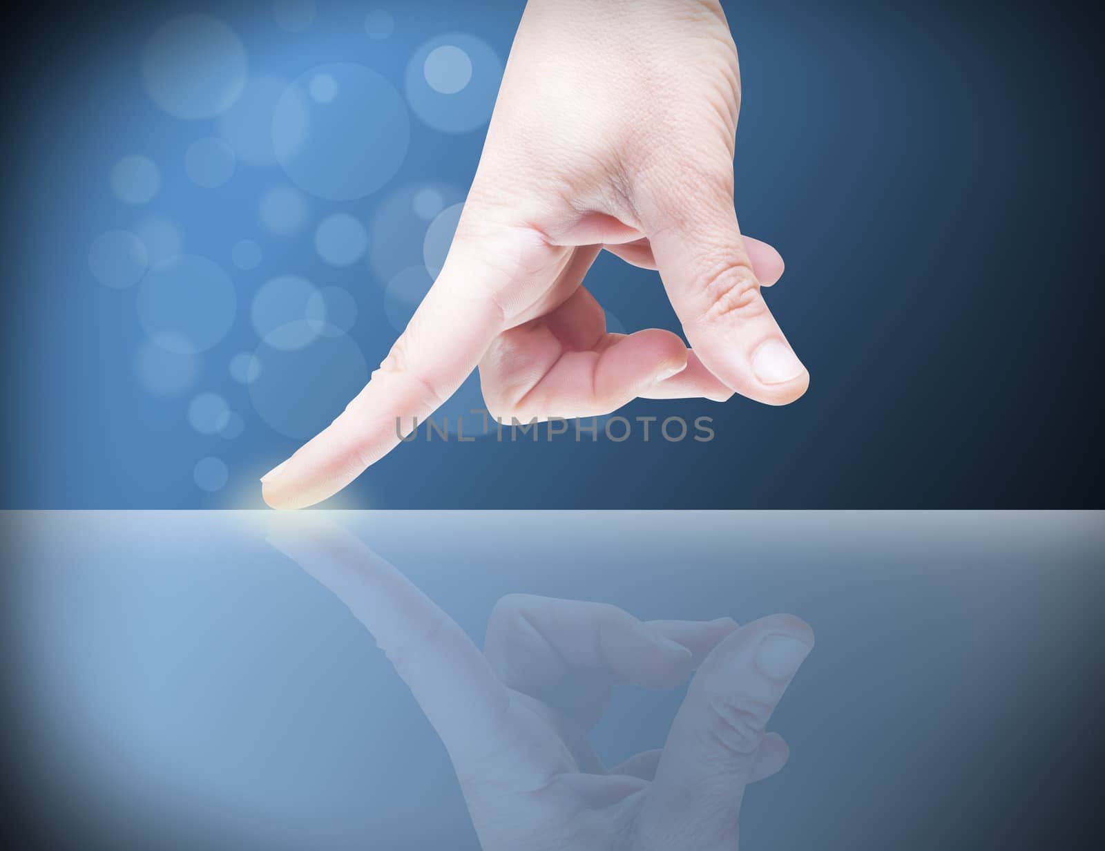 Picture of a finger pointing on a transparent device.