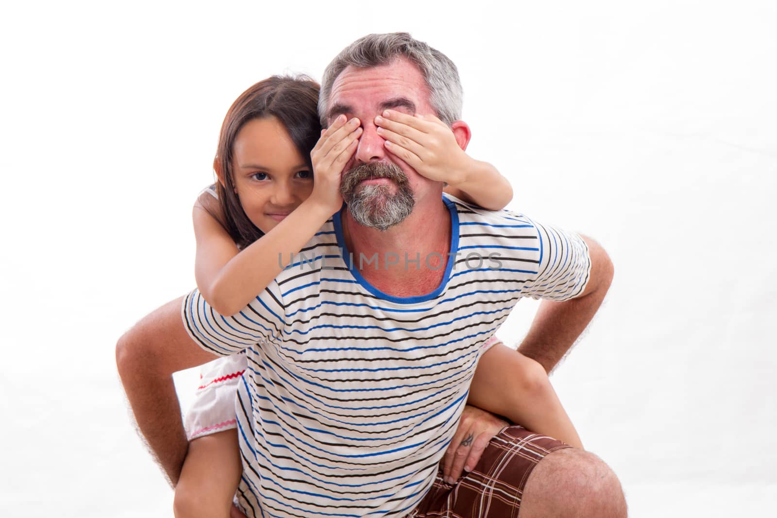 Caucasian father holding mixed race daughter, child covering dad's eyes