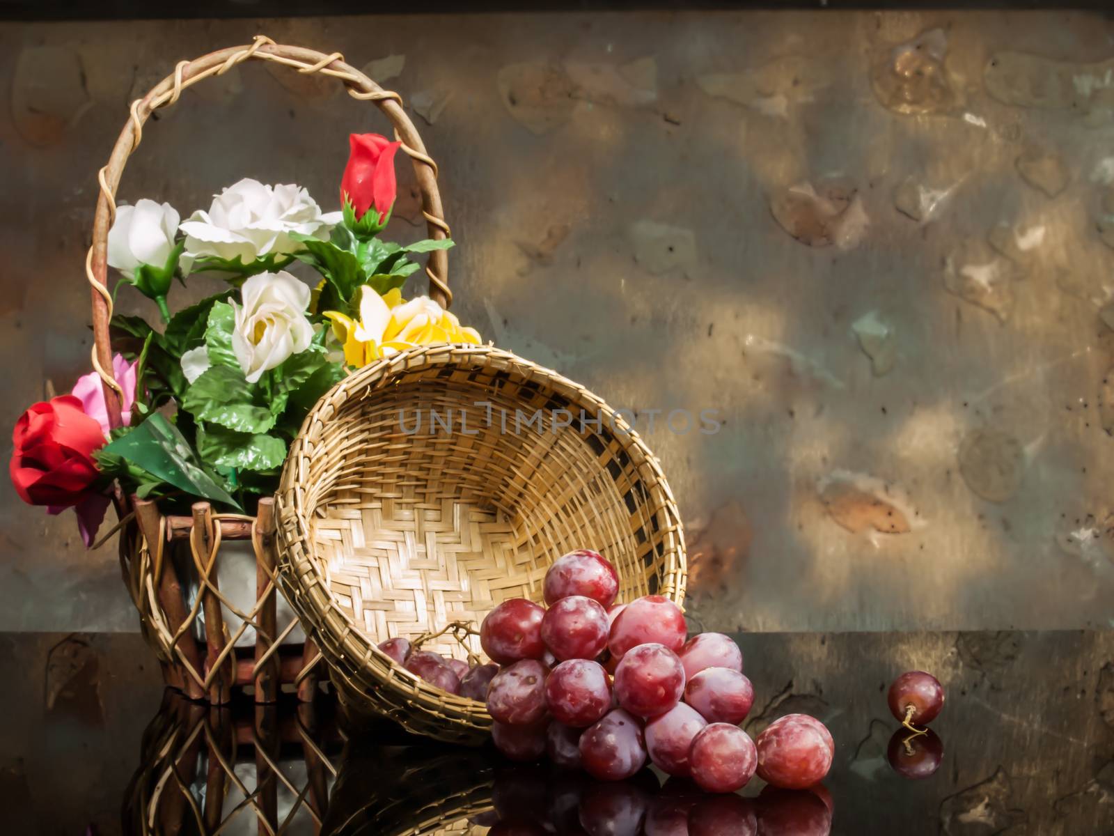 red grapes served in basket on black glass and on wood and Flower Basket background