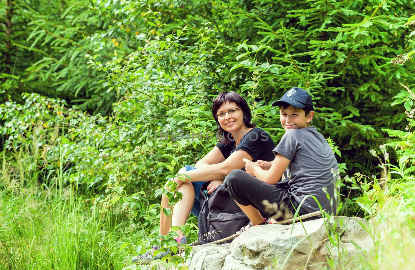 Portrait of family sitting on a bridge in forest by artush