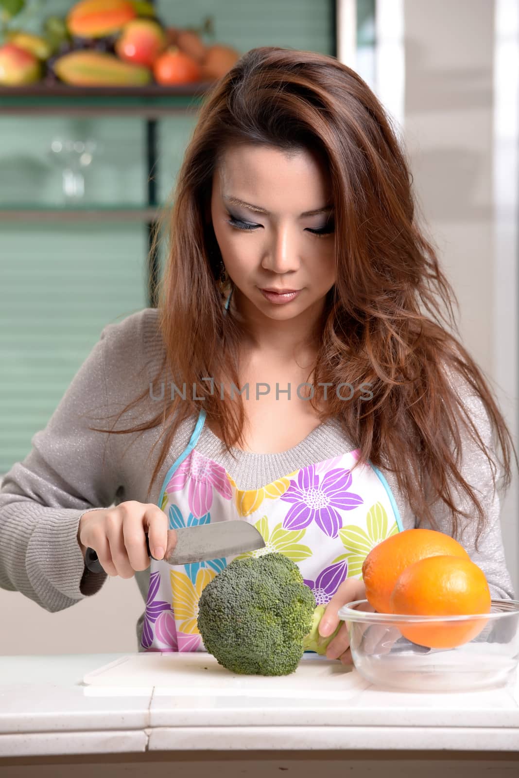 Happy asian woman cooking in the kitchen by Yuri2012