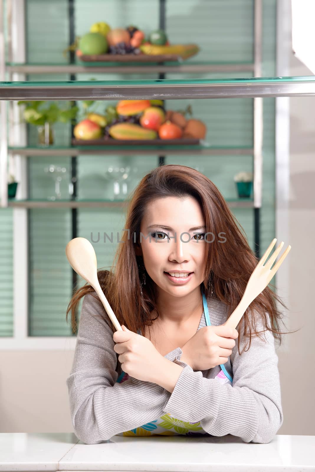 Happy asian woman cooking in the kitchen by Yuri2012