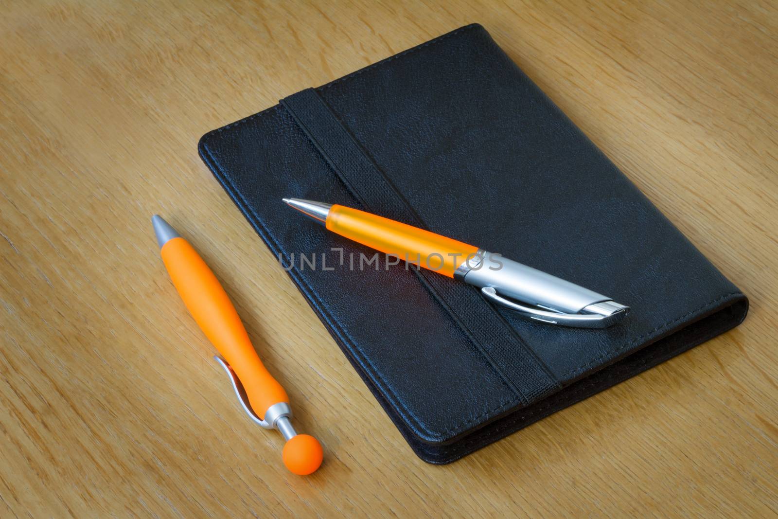 
Two handles of bright orange color for the letter and multi-colored paper clips for documents. Are located on a table