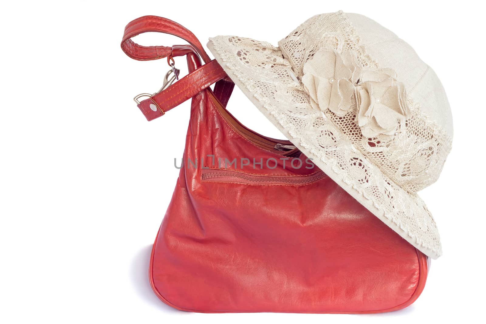 Female hat from a linen cloth and lacy fabric for protection against the sun and a leather bag. Are presented on a white background.