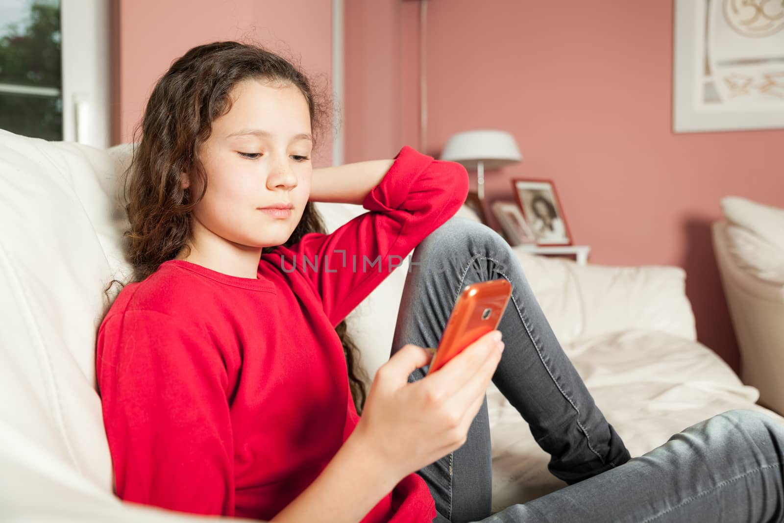 An image of a young girl with a mobile phone