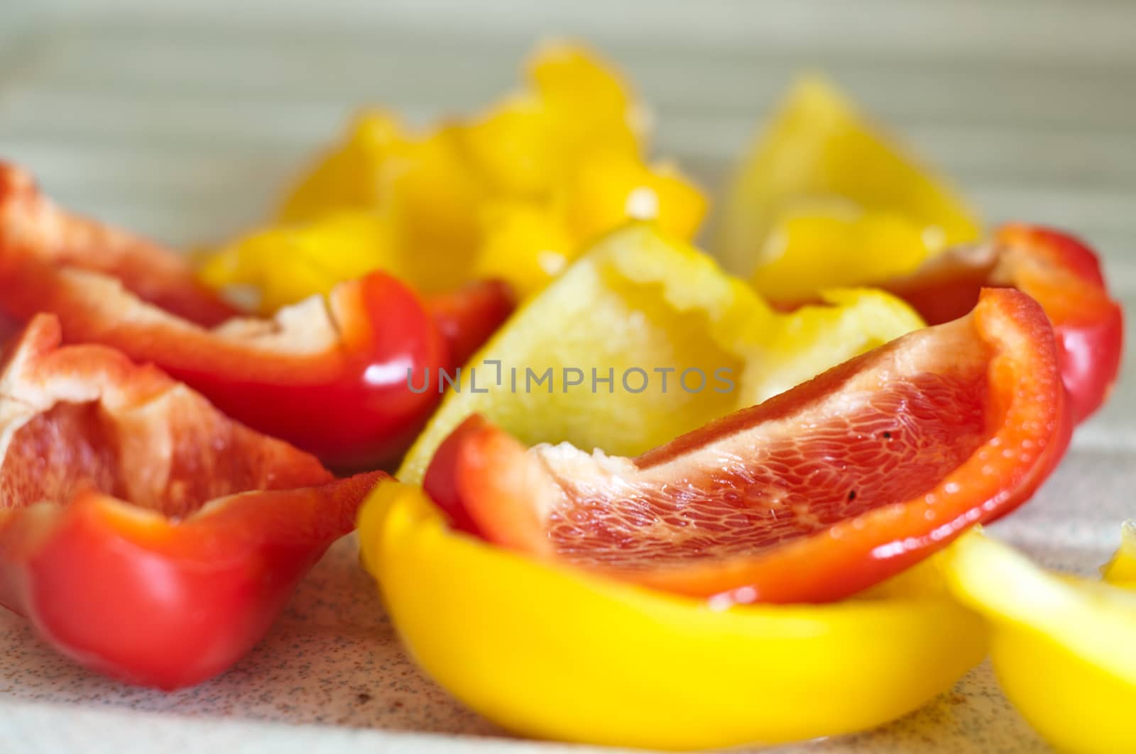 red and yellow peppers cut on wooden board