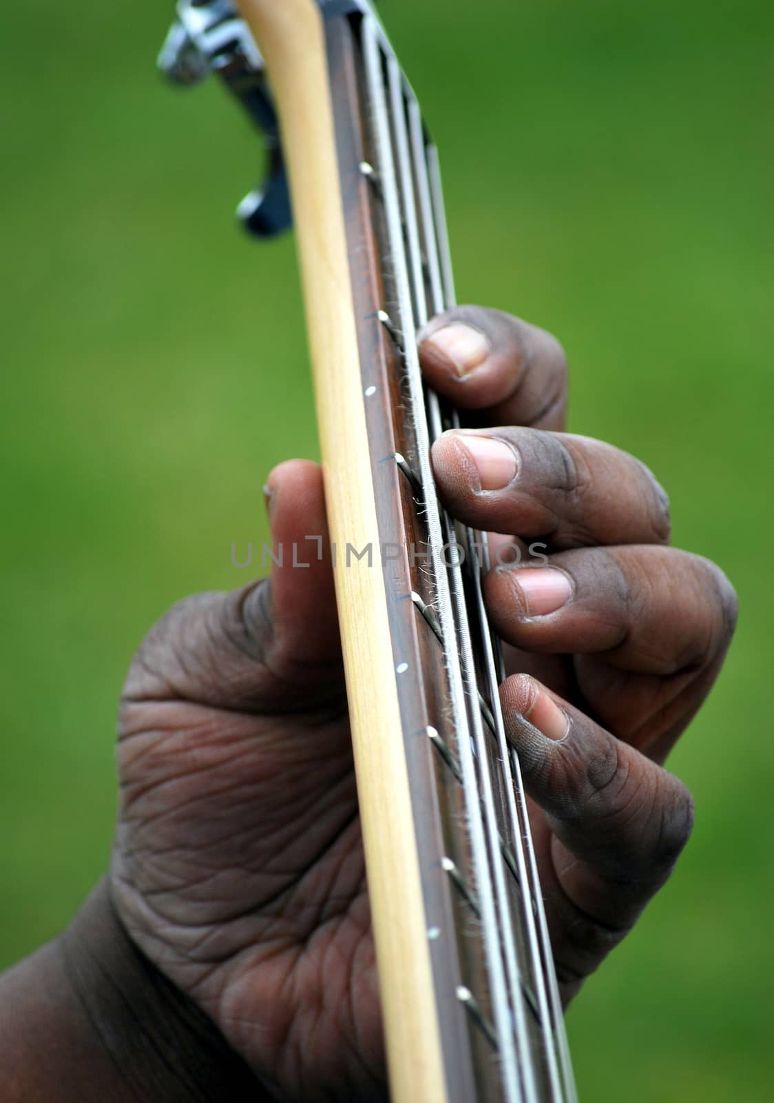 Electric bass guitar played by an african american male.