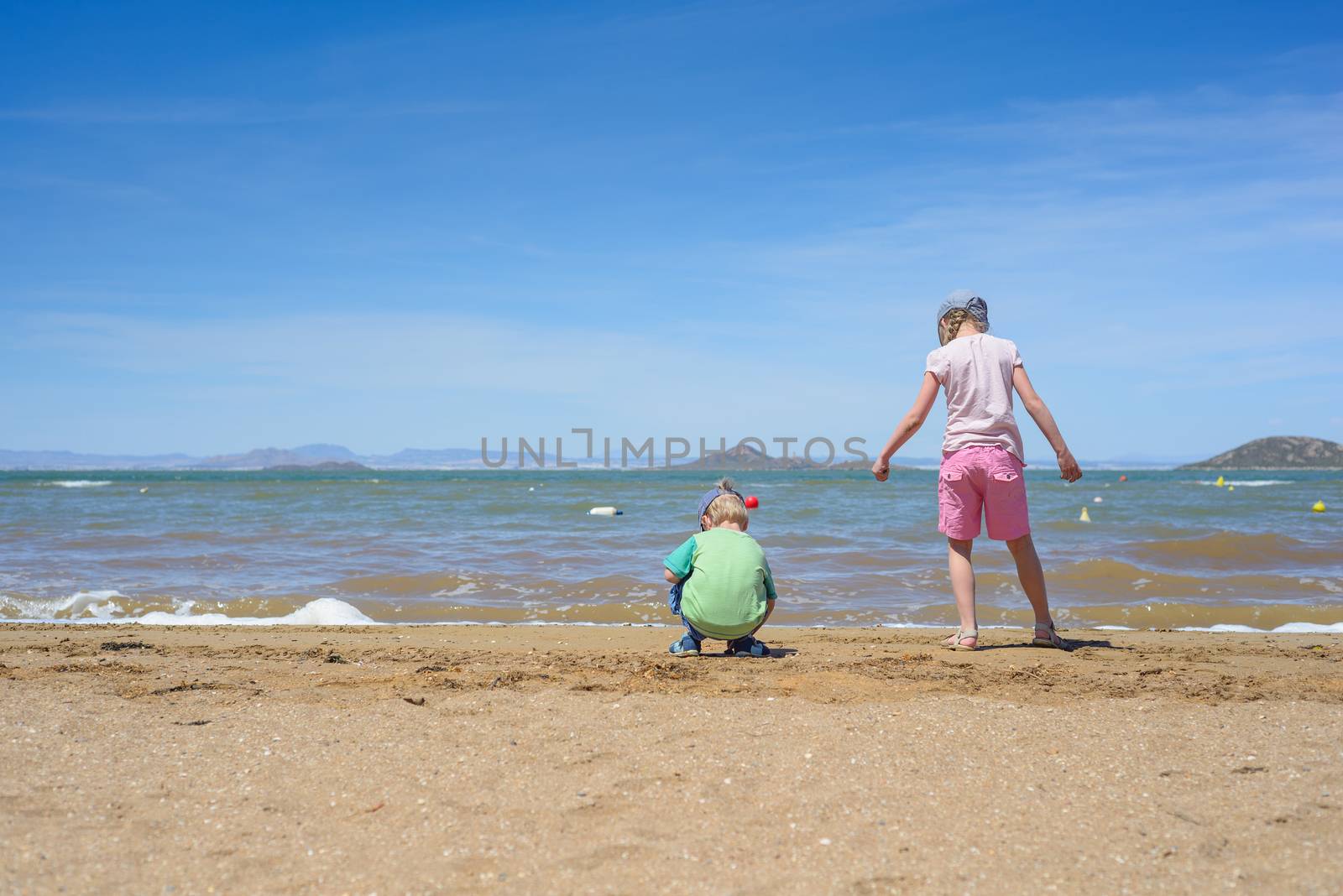 Little boy and girl playing on the beach by anytka