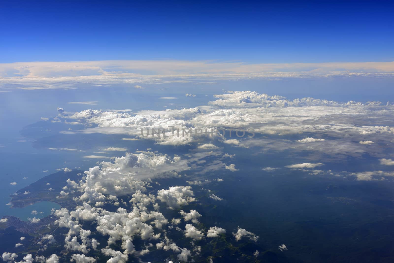 Earth's surface with sea and clouds. Top view of aircraft