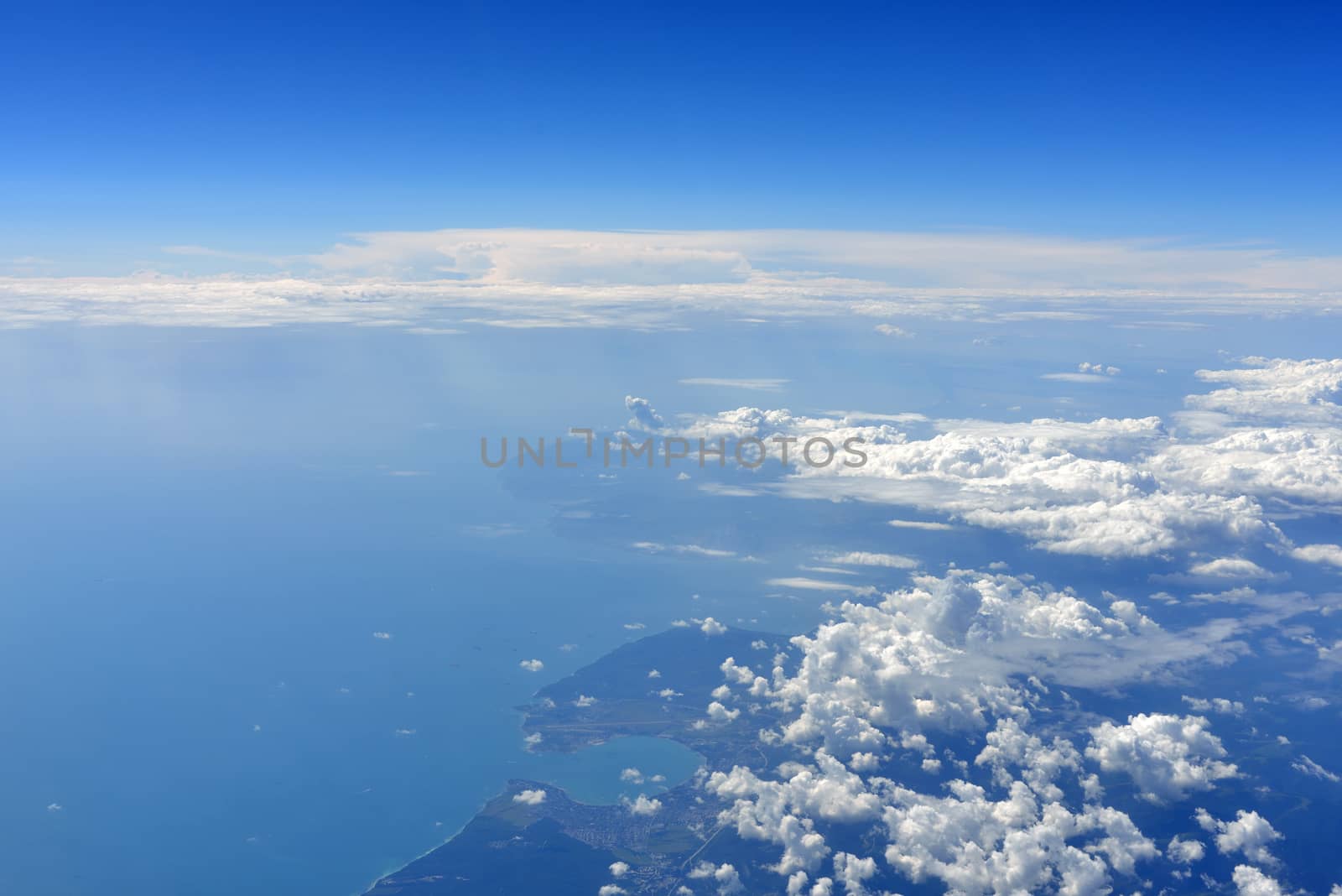 Earth's surface with sea and clouds. Top view of aircraft