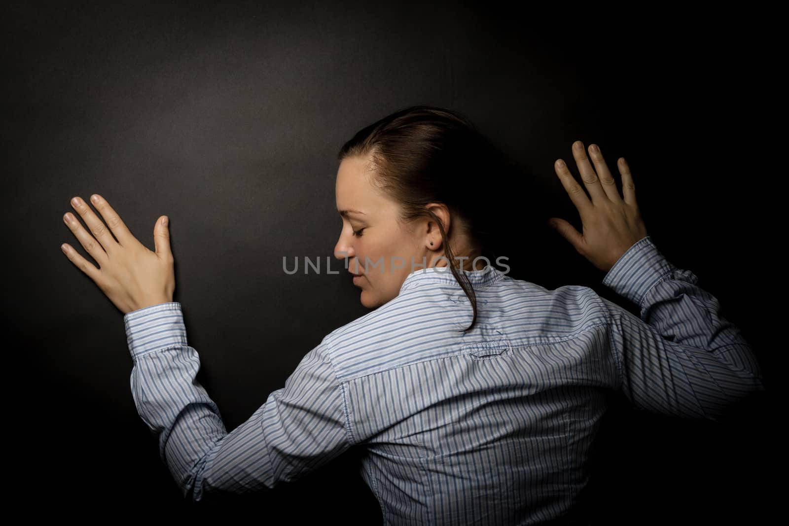 young woman leaning on dark paper background