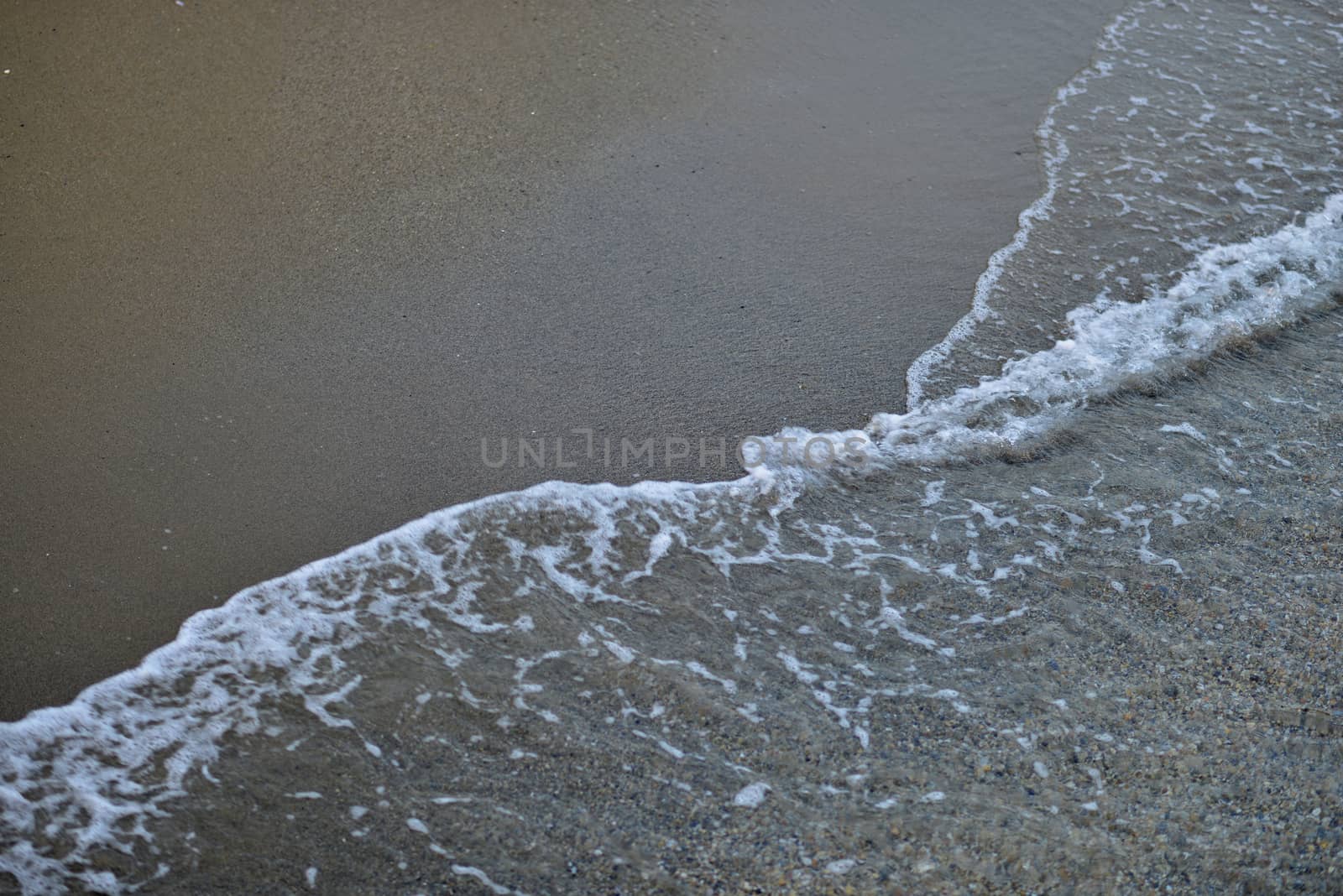 Seawater on the sandy beach. Natural background