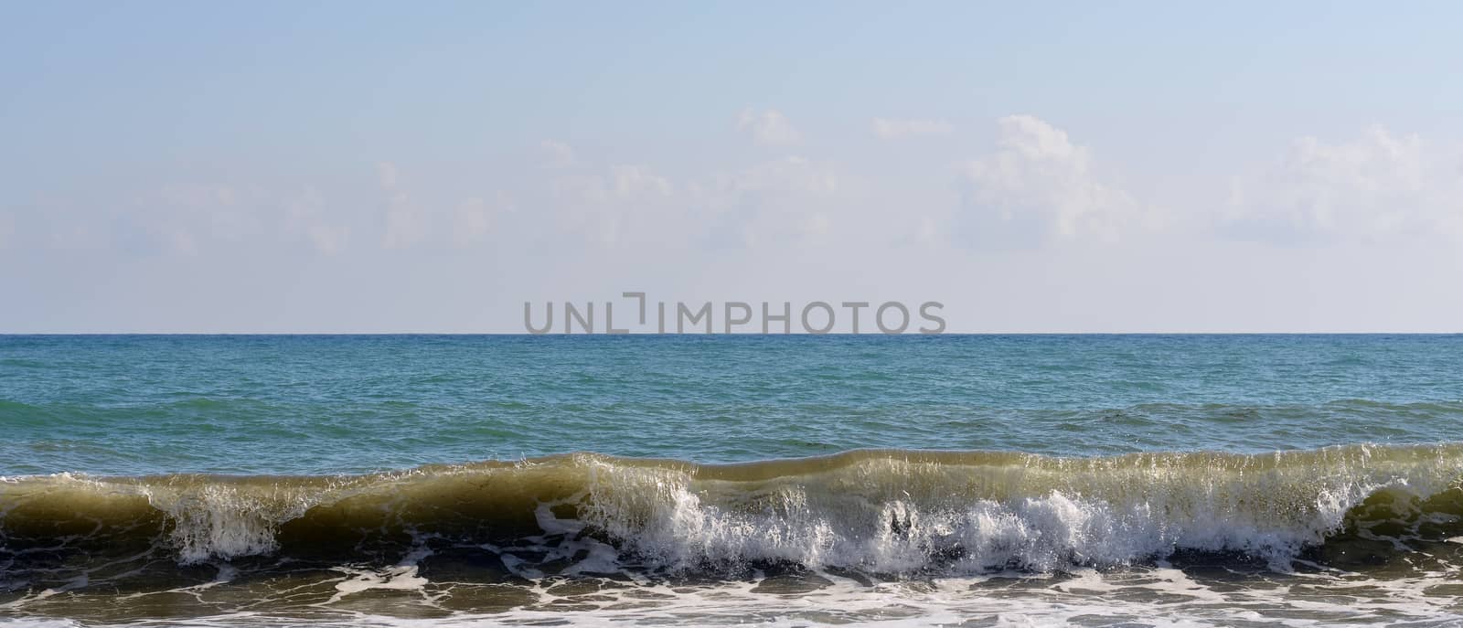 Sea wave rolled ashore. Blue sky in the background