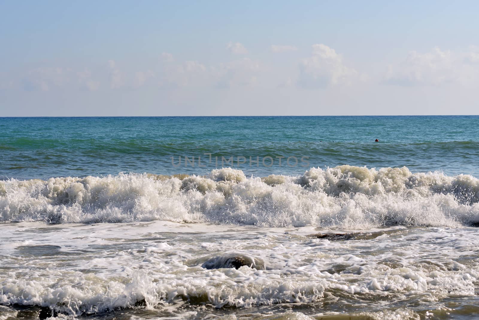 Sea wave rolled ashore. Blue sky in the background