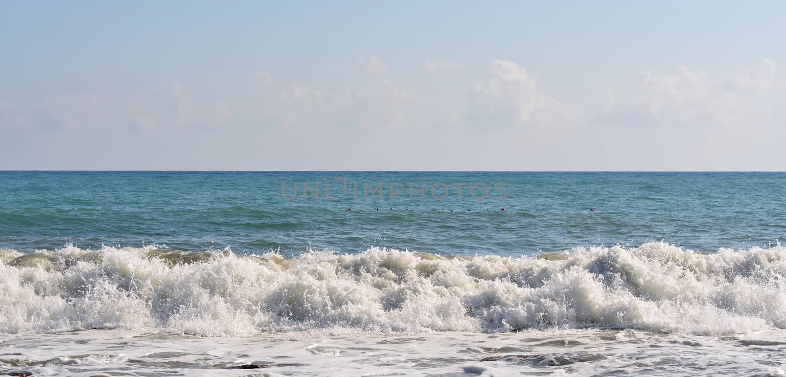 Sea wave rolled ashore. Blue sky in the background