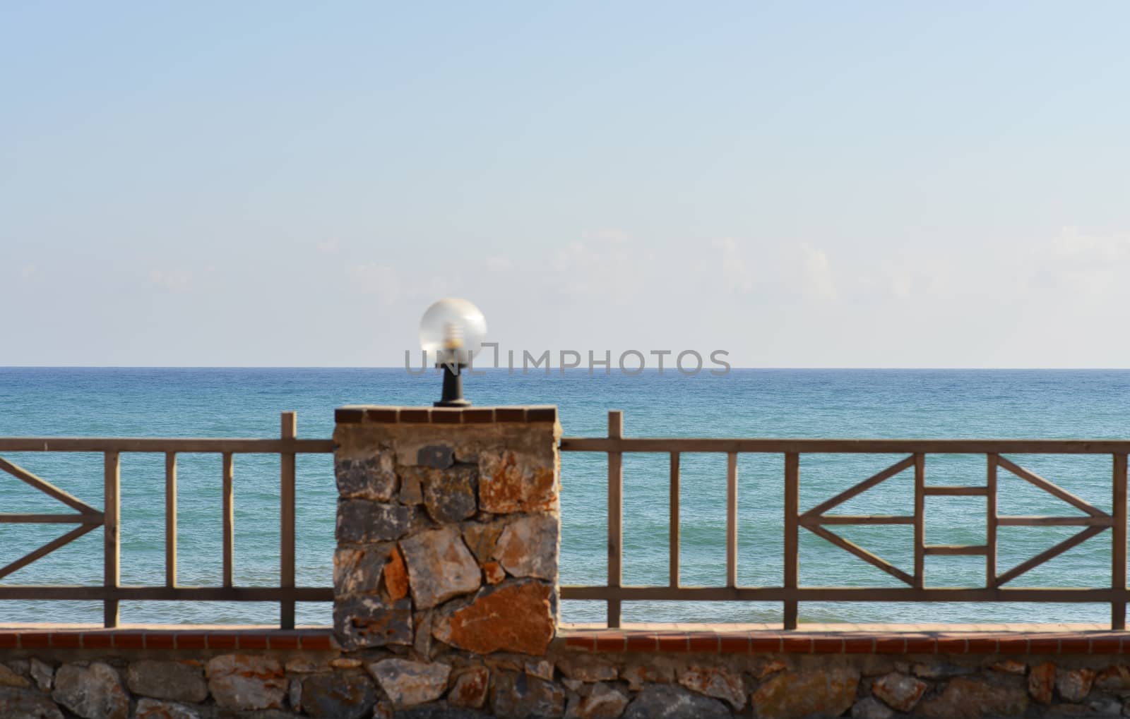Railing with lights on background of sea and sky