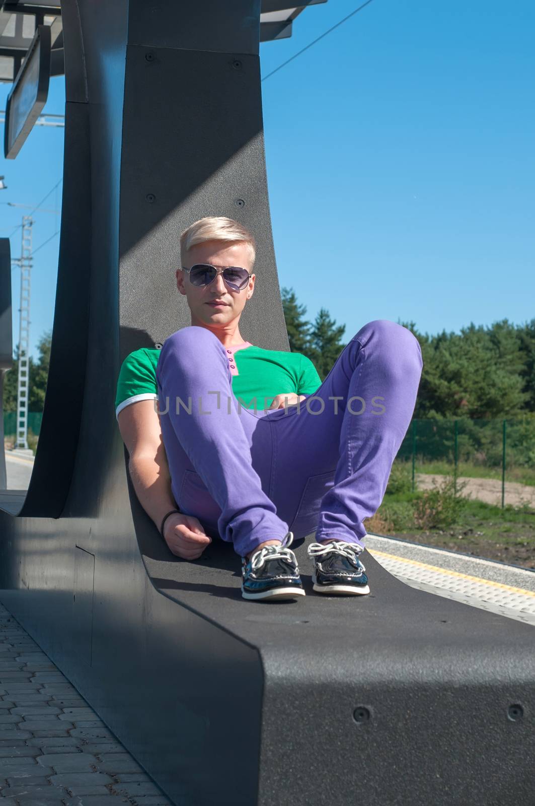 Handsome blond man in sunglasses sitting on the seat