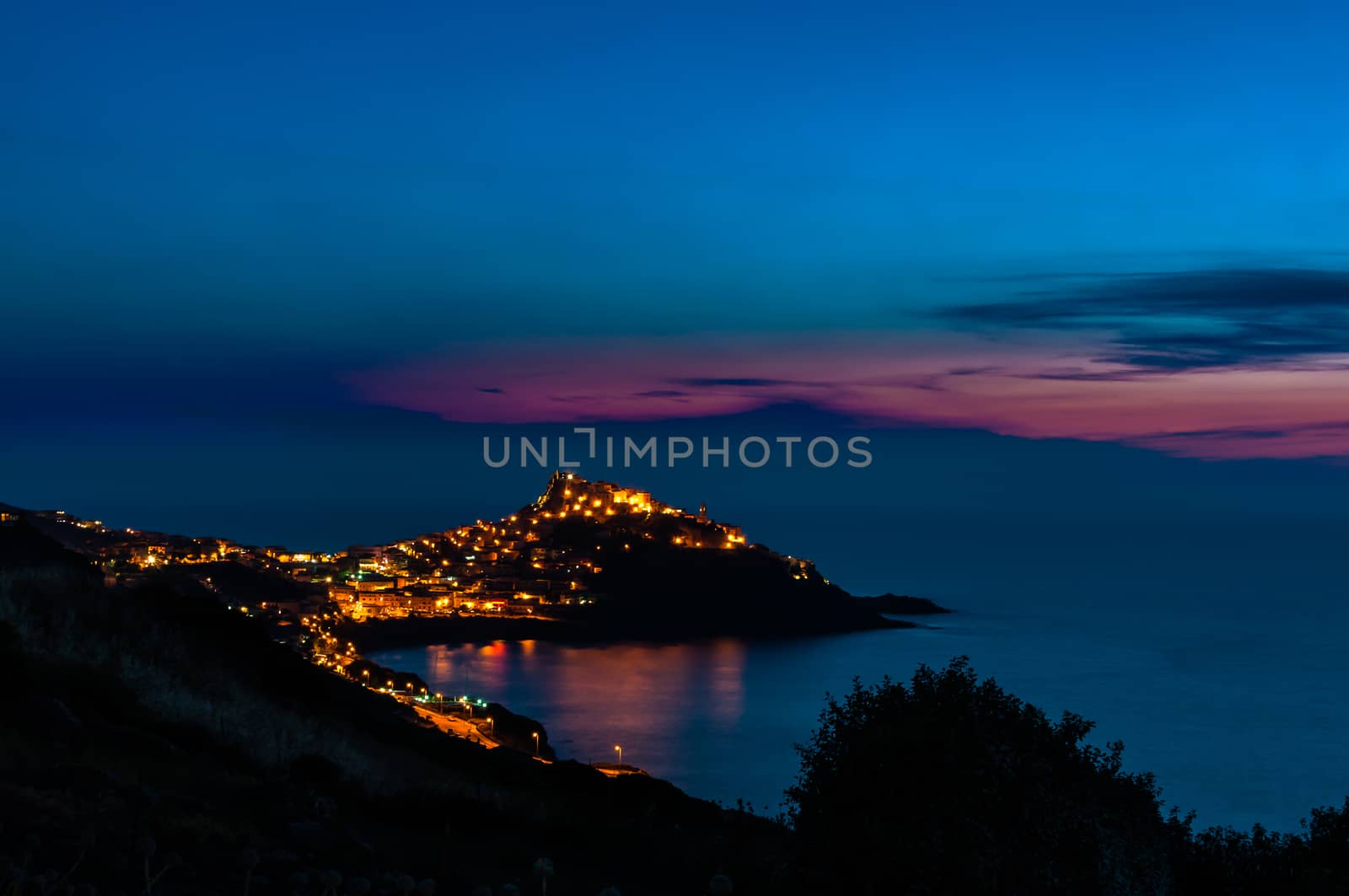 a view of Castelsardo , Sardinia, illuminated by streetlights with the last light of dusk