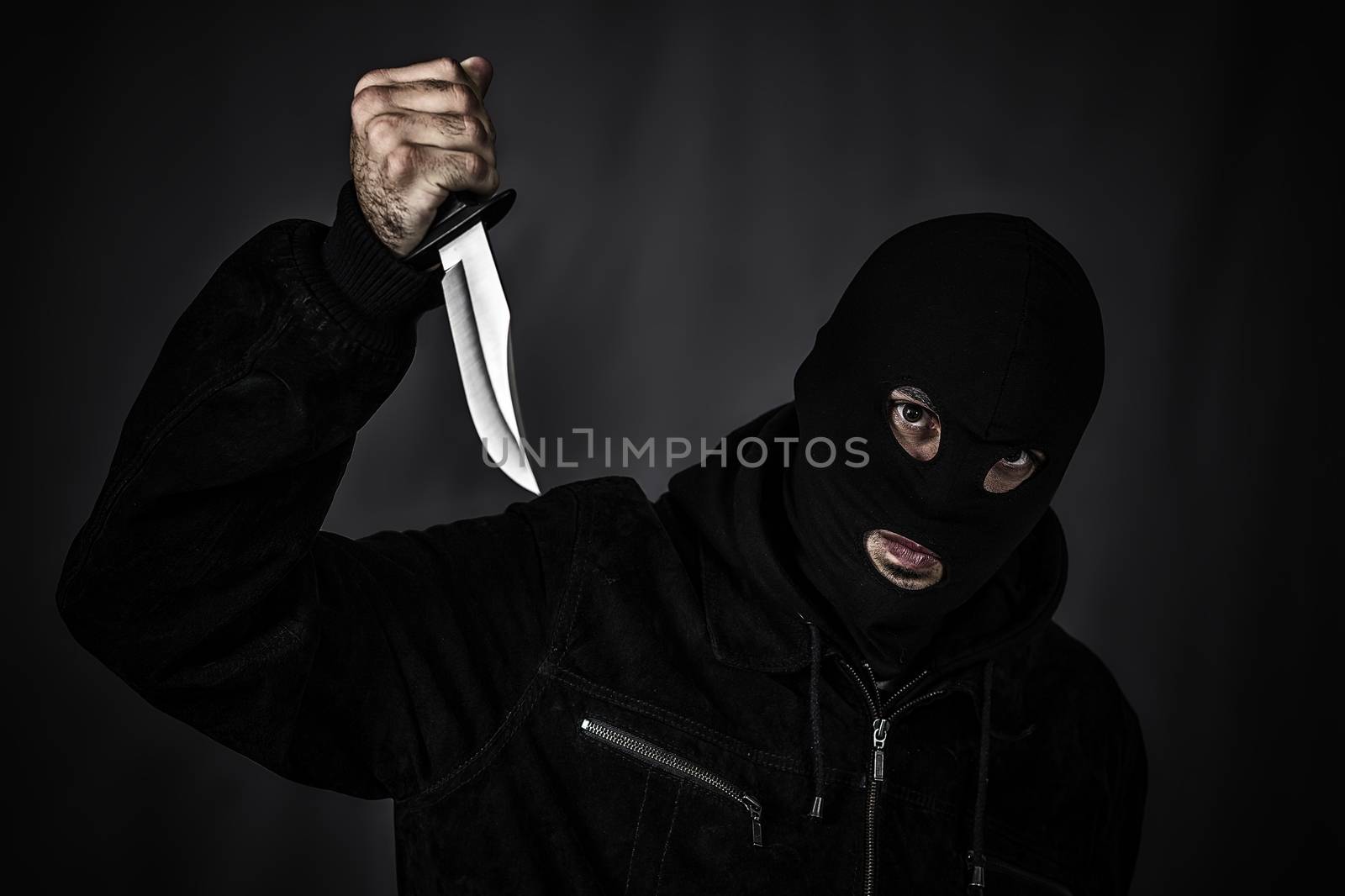 Thief in the hood on a black background 