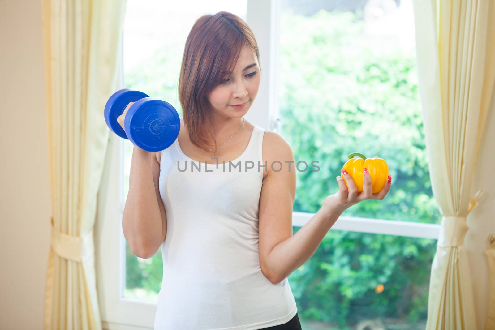 Portrait of a healthy asian woman with vegetables and dumbbell in home