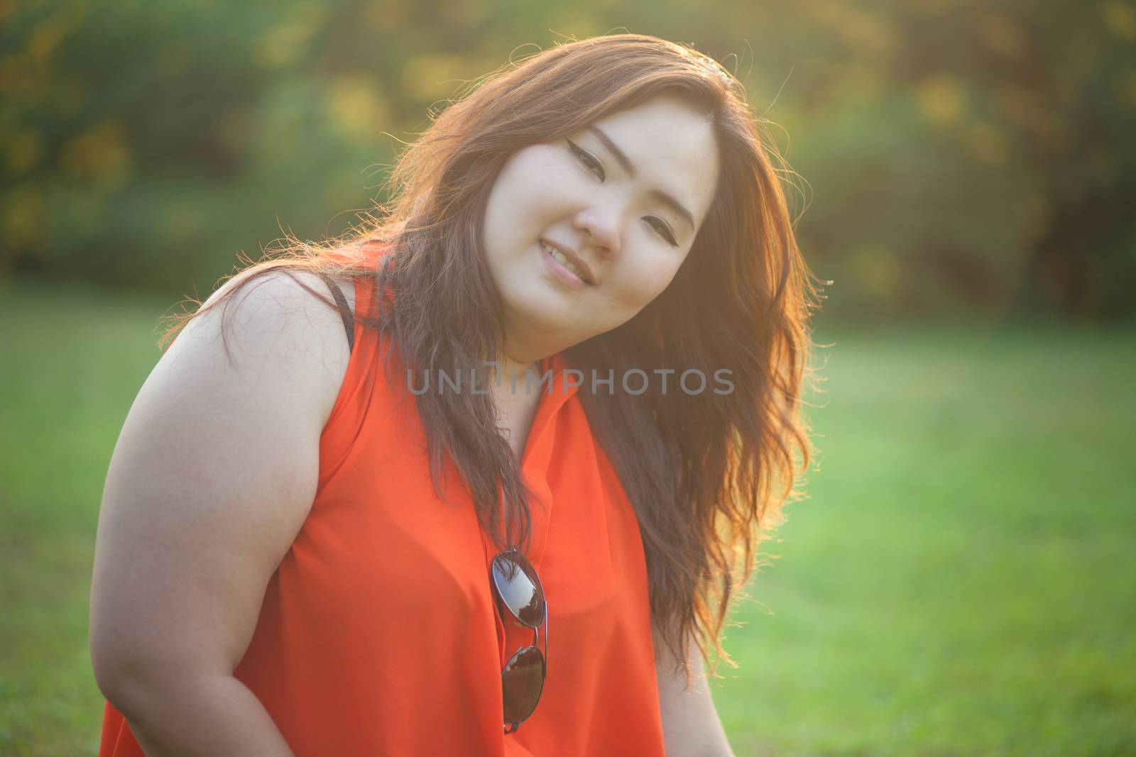 Close up of happy fatty asian woman outdoor in a park