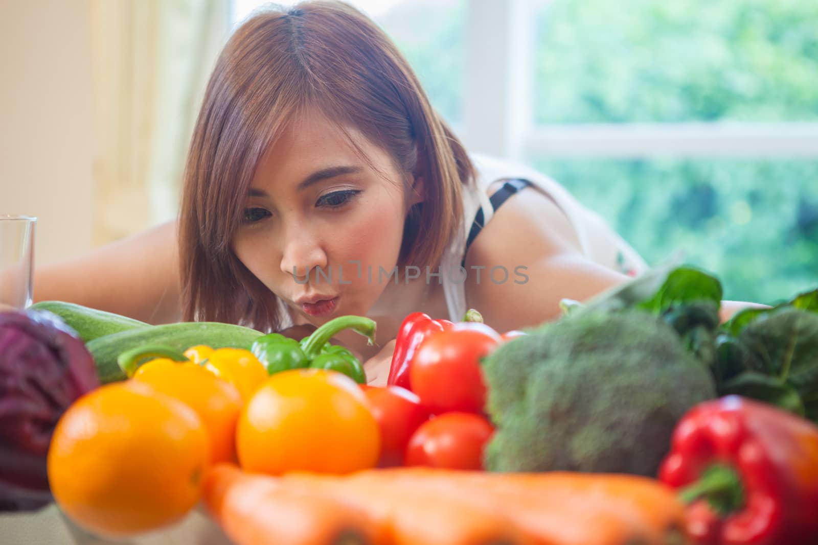 Happy asian woman cooking vegetables green salad in the kitchen