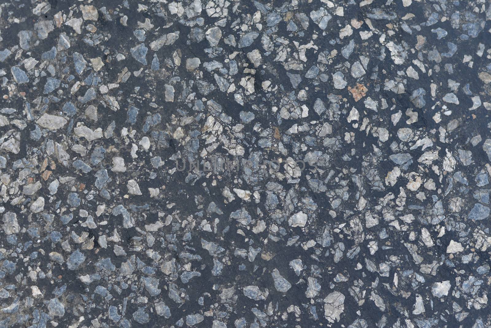 Dark asphalt surface much relief. Close up