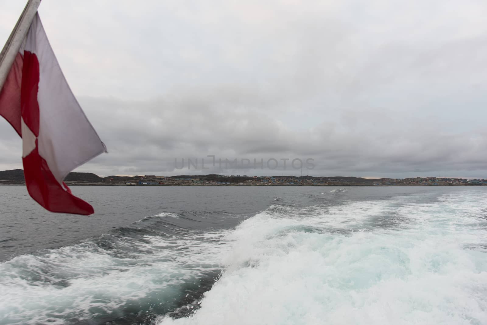 The flag of greenland on a ship cruising in the waters around Aasiaat