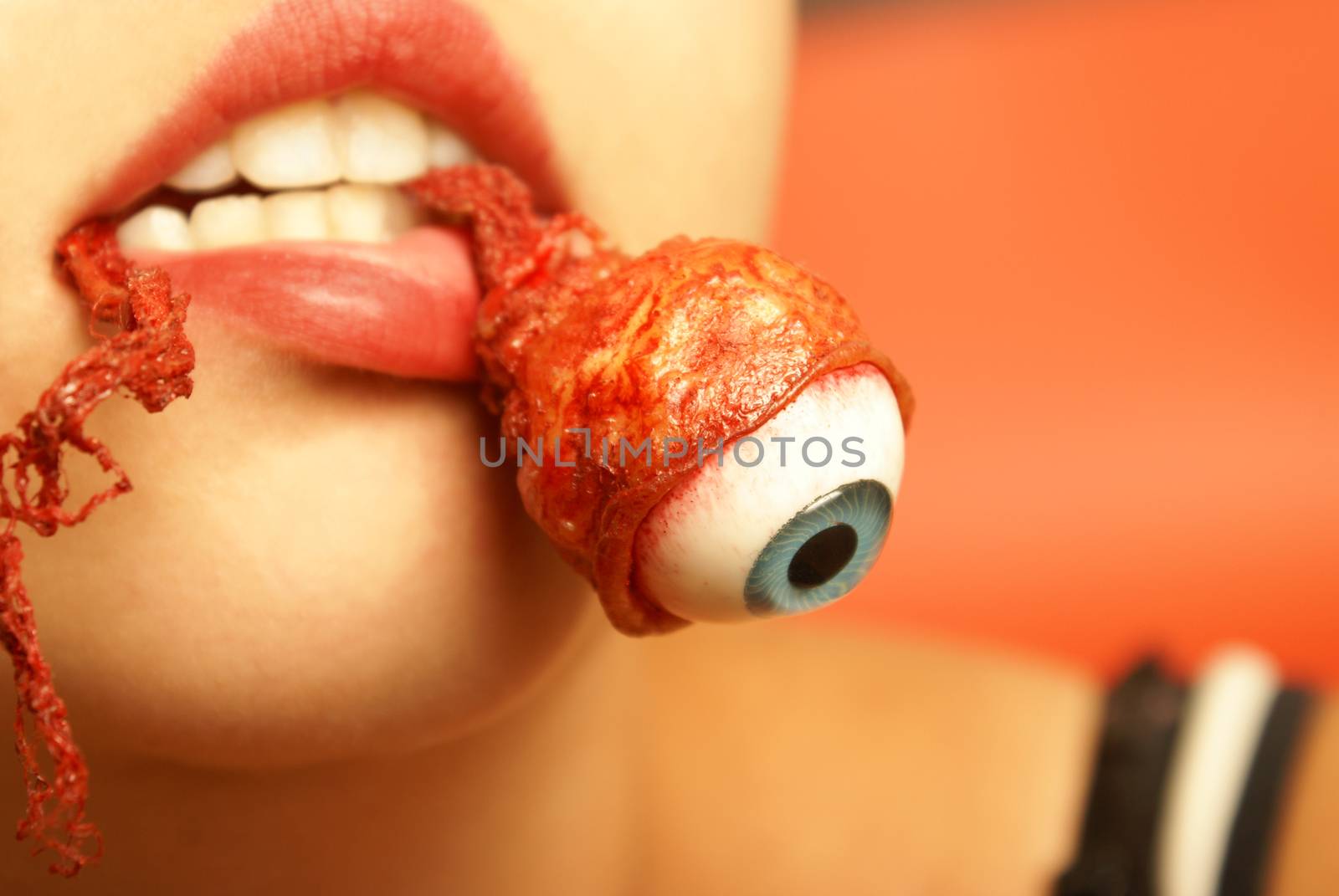 A woman takes a bite out of an eyeball.