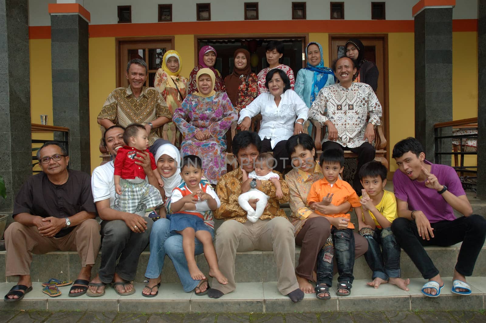 bandung, indonesia-december 19, 2010: large group of family gathering together in front of house.
