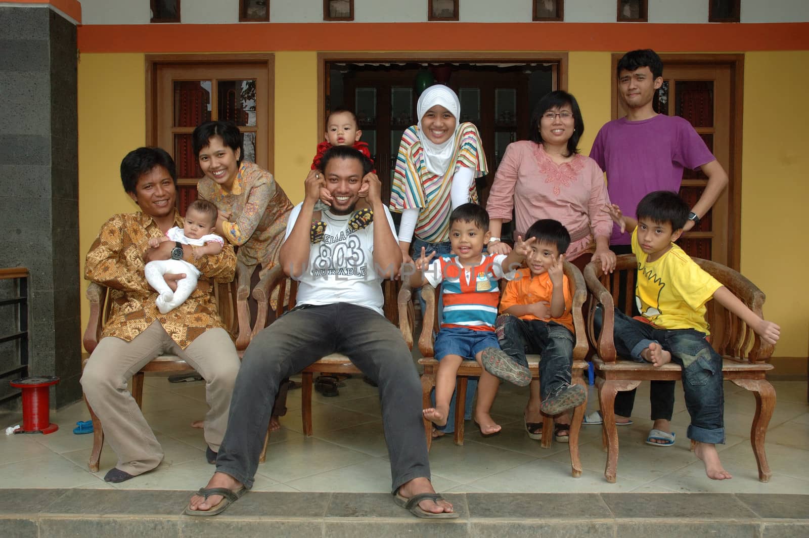 bandung, indonesia-december 19, 2010: large group of family gathering together in front of house.