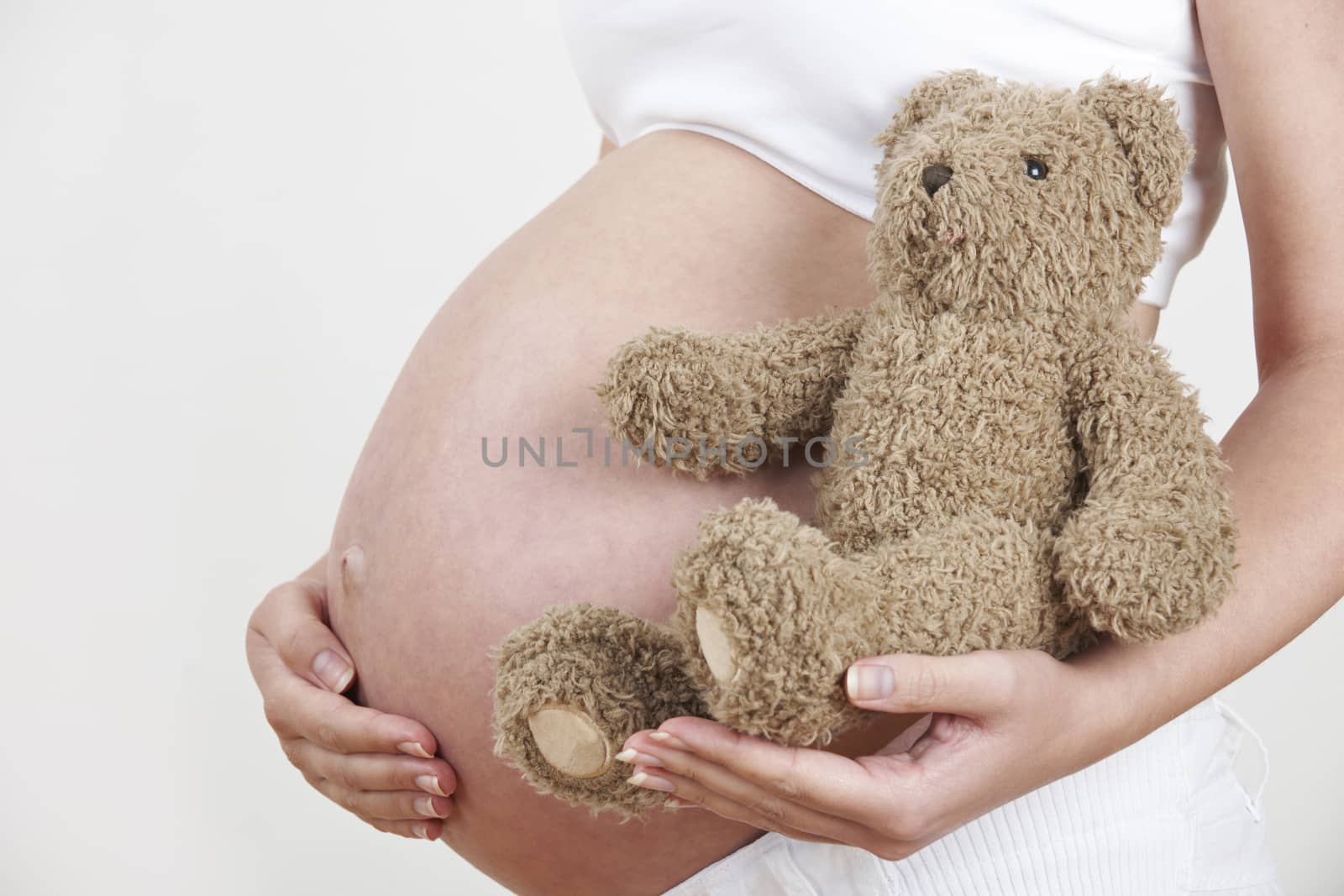 Close Up Of Pregnant Woman Holding Teddy Bear by HighwayStarz
