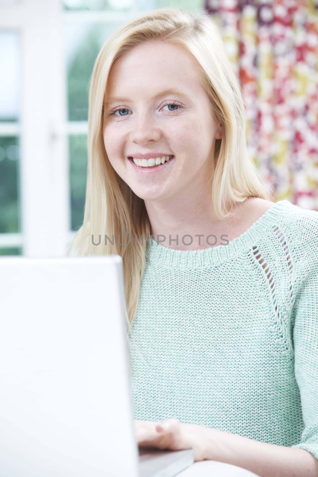 Smiling Teenage Girl Using Laptop At Home by HighwayStarz