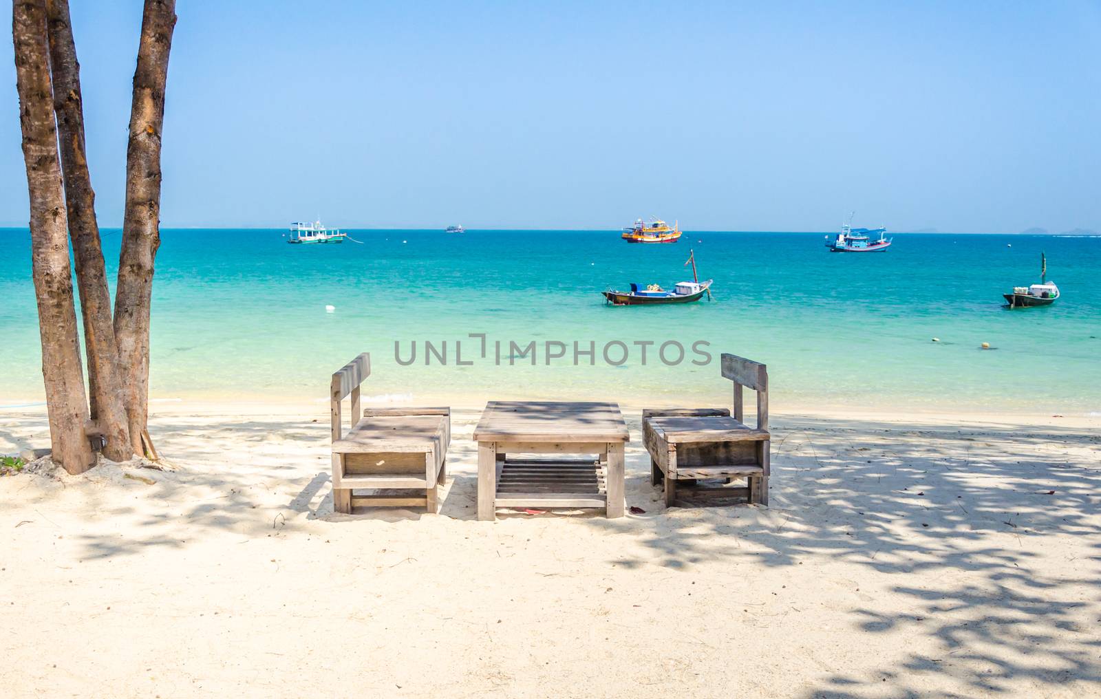 Empty wooden table on the beach by wanichs