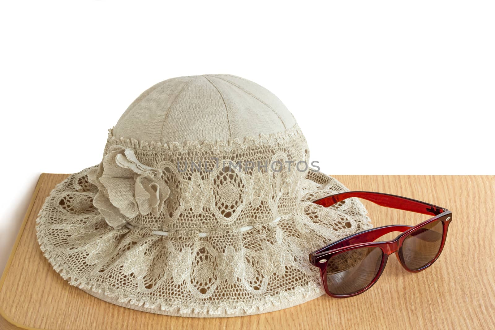 Female hat from a linen cloth and lacy fabric for protection against the sun. It is presented on a white background.