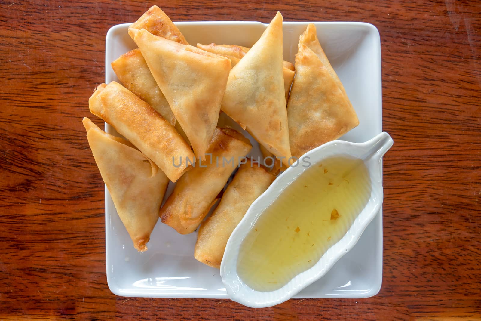 Fry Spring Roll With Sweet Sauce Serve in a White Dish on a Wood Table