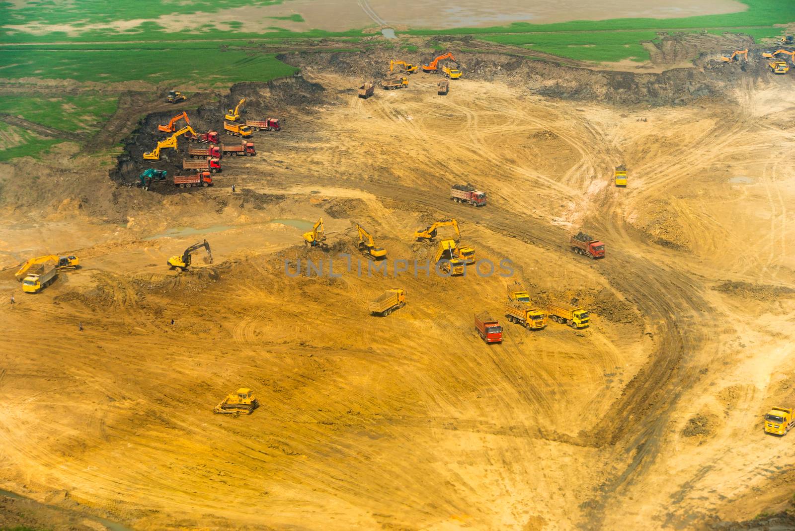 Wheel loader Excavator unloading sand, tractors and dump truck inside construction site