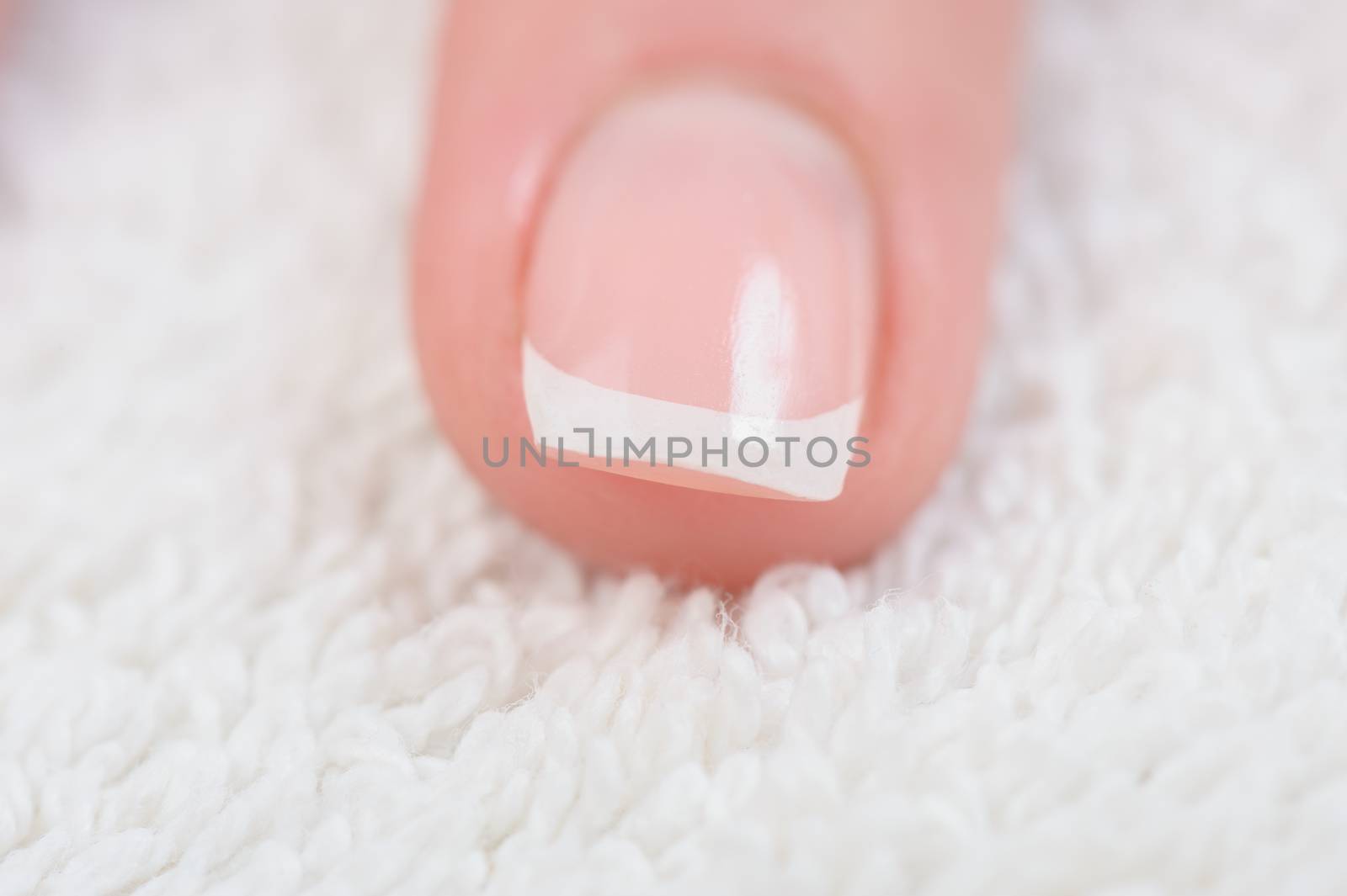 Fingers with french manicure on white towel